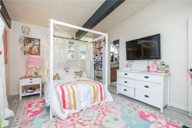 bedroom featuring vaulted ceiling, light hardwood / wood-style floors, and ensuite bathroom