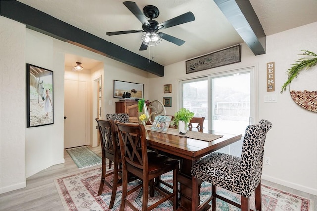 dining space featuring beamed ceiling, ceiling fan, and light hardwood / wood-style floors