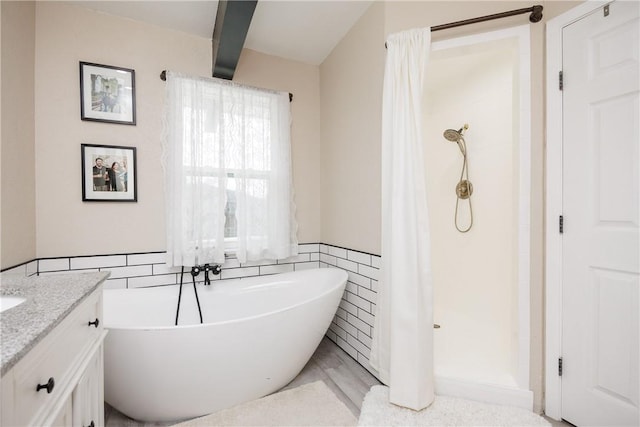 bathroom featuring vanity, tile walls, and a washtub