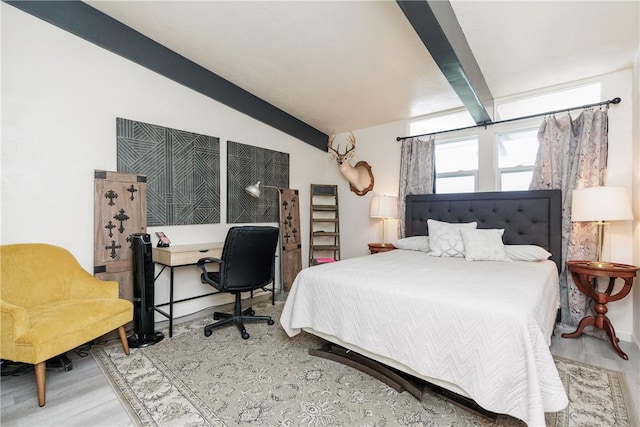 bedroom featuring hardwood / wood-style flooring and vaulted ceiling with beams