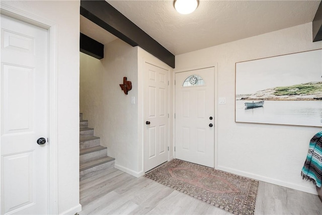 entryway with a textured ceiling and light wood-type flooring