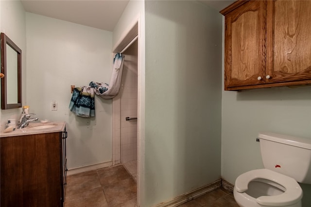 bathroom with vanity, tile patterned flooring, toilet, and a tile shower