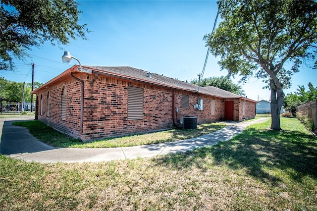 view of side of home with cooling unit and a lawn