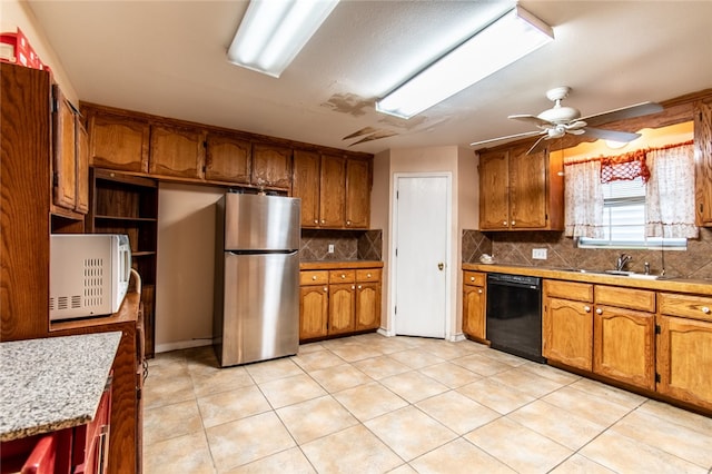 kitchen with sink, tasteful backsplash, ceiling fan, stainless steel fridge, and black dishwasher