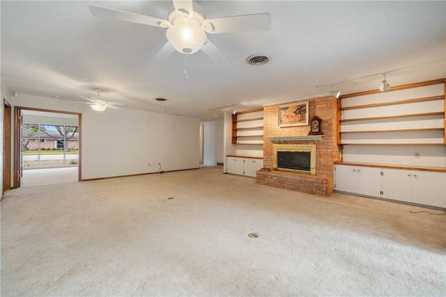 unfurnished living room with ceiling fan, a fireplace, and light carpet