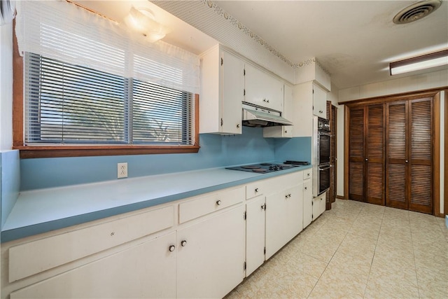 kitchen featuring black electric cooktop, light tile patterned floors, double oven, and white cabinets