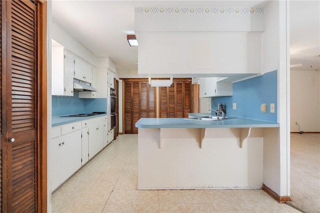 kitchen with sink, kitchen peninsula, cooktop, and white cabinets