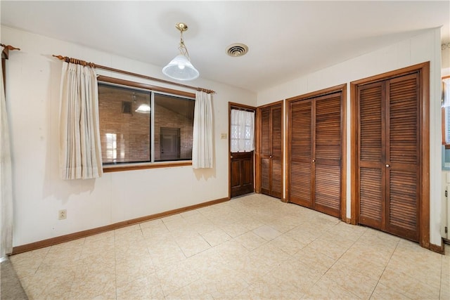 unfurnished bedroom with two closets