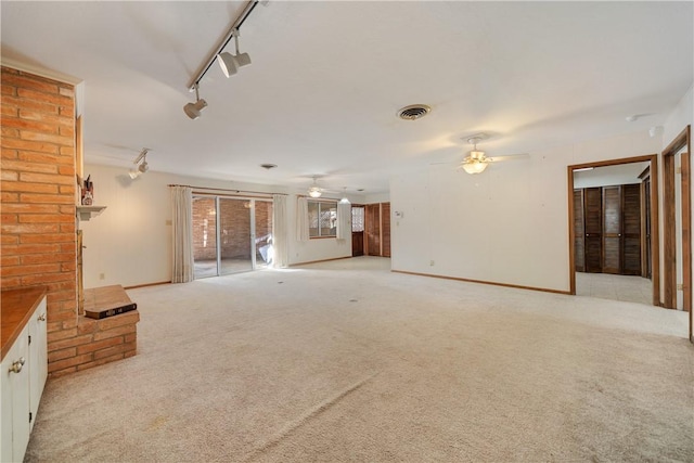 unfurnished living room with ceiling fan, light colored carpet, and track lighting