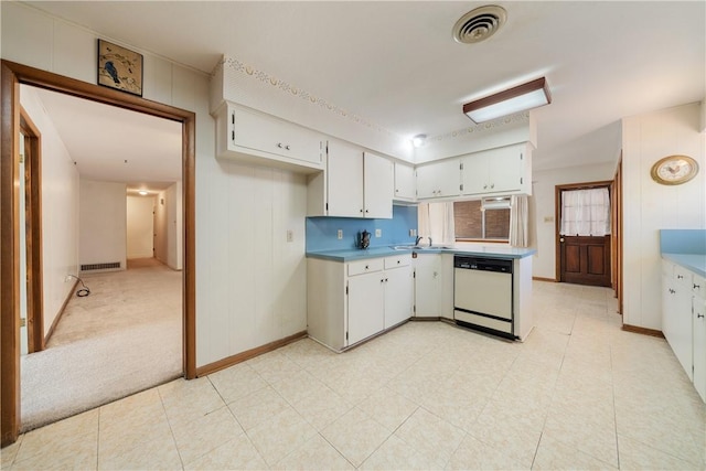 kitchen with white cabinetry, dishwasher, sink, and light colored carpet