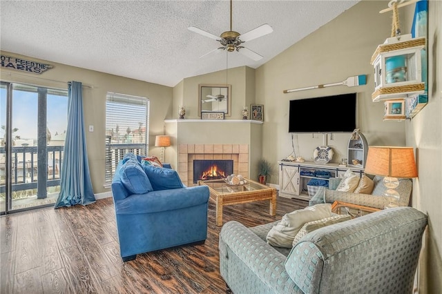 living room featuring a tile fireplace, dark wood-type flooring, a textured ceiling, and lofted ceiling