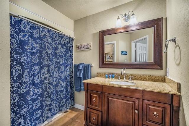 bathroom with a textured ceiling, tile patterned floors, and vanity