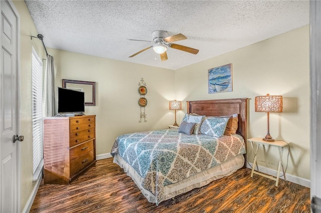 bedroom with a textured ceiling, dark hardwood / wood-style floors, and ceiling fan