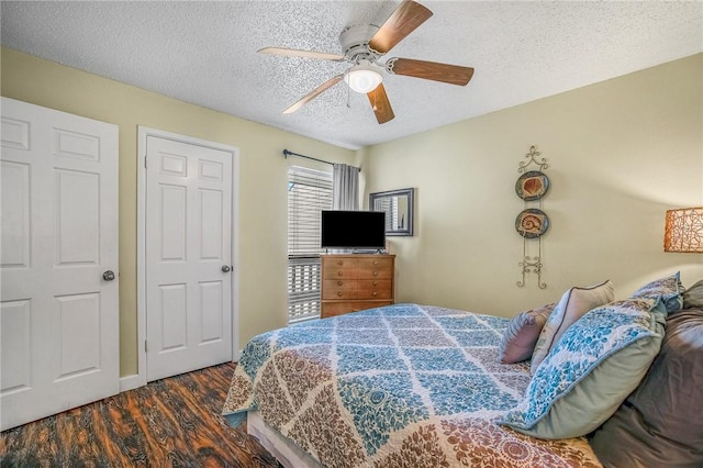 bedroom featuring ceiling fan, dark wood-type flooring, and a textured ceiling