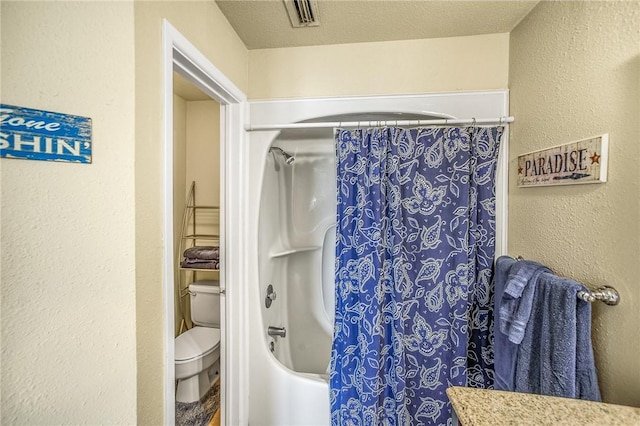 bathroom with a textured ceiling, toilet, and shower / bath combo