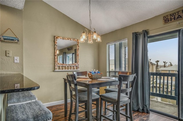 dining space featuring an inviting chandelier, a textured ceiling, and lofted ceiling