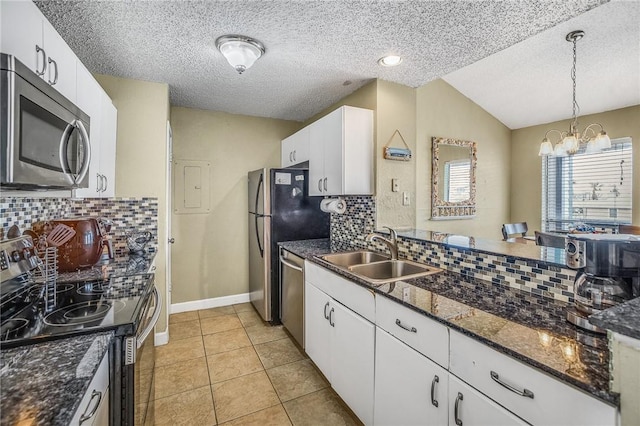 kitchen with appliances with stainless steel finishes, a textured ceiling, white cabinets, sink, and pendant lighting