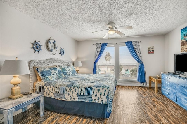 bedroom with ceiling fan, dark hardwood / wood-style floors, and a textured ceiling