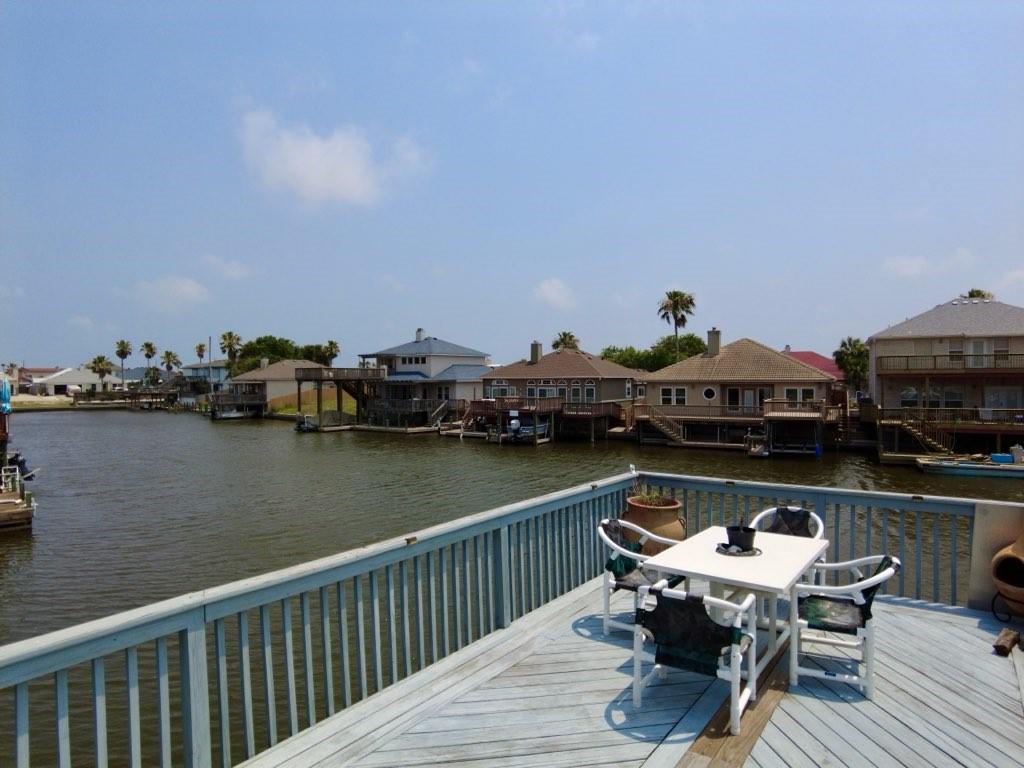 dock featuring outdoor dining space, a deck with water view, and a residential view