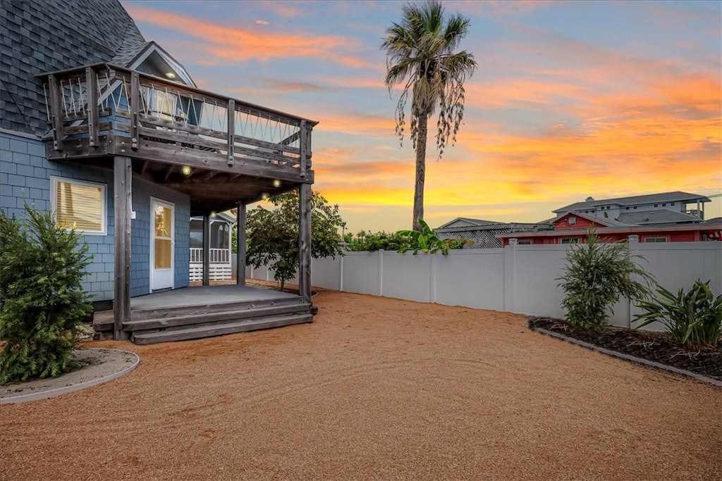 yard at dusk featuring a deck