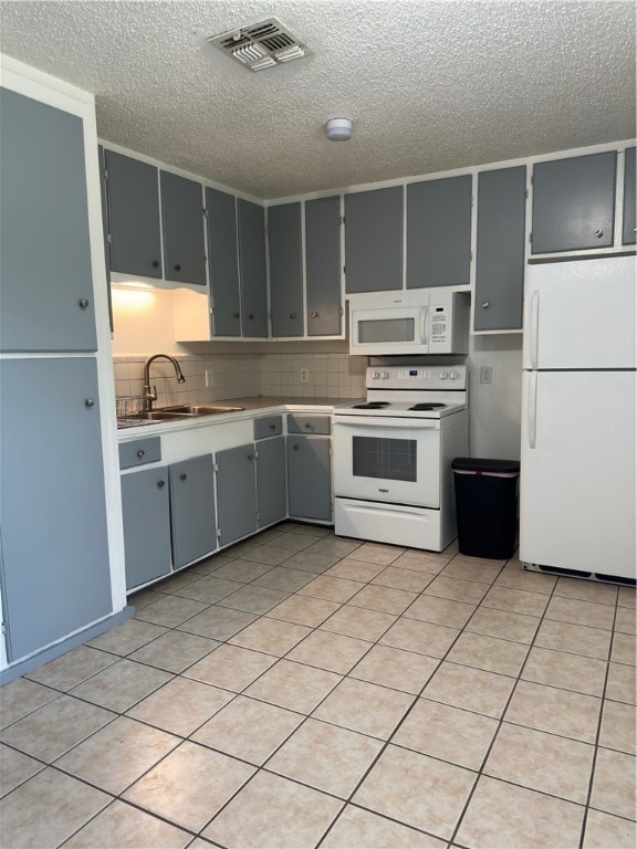 kitchen featuring gray cabinetry, tasteful backsplash, light tile patterned floors, sink, and white appliances