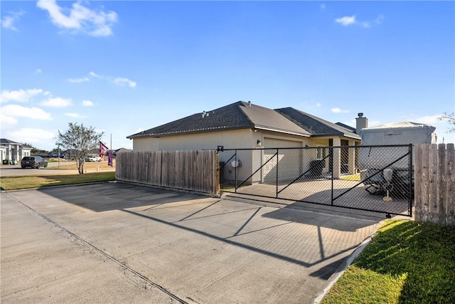 6401 Kobe Dr, Corpus Christi, TX 78414 - rear view of house with a gate, a garage, and stucco siding