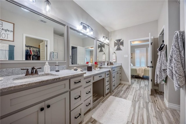 6401 Kobe Dr, Corpus Christi, TX 78414 - bathroom with ensuite bath, double vanity, a spacious closet, and wood finished floors