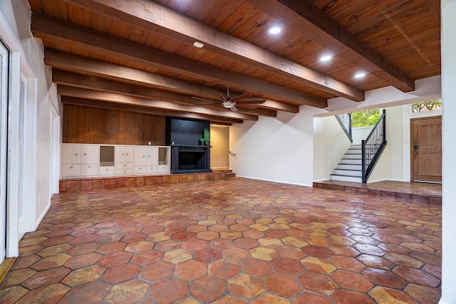 unfurnished living room featuring ceiling fan, beam ceiling, and wood ceiling