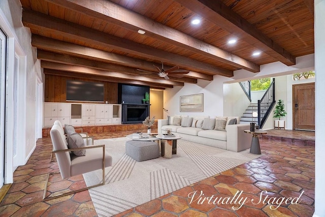 living room featuring beam ceiling, ceiling fan, and wood ceiling