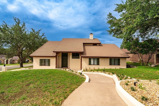 mediterranean / spanish-style house with a front yard