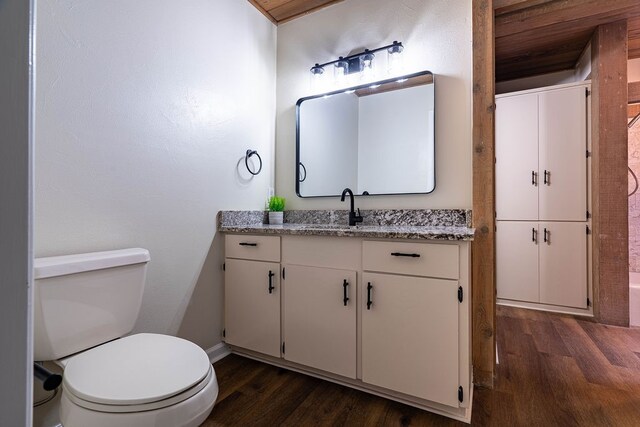 bathroom with toilet, vanity, and hardwood / wood-style flooring