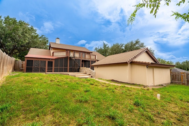 back of house featuring a sunroom and a lawn