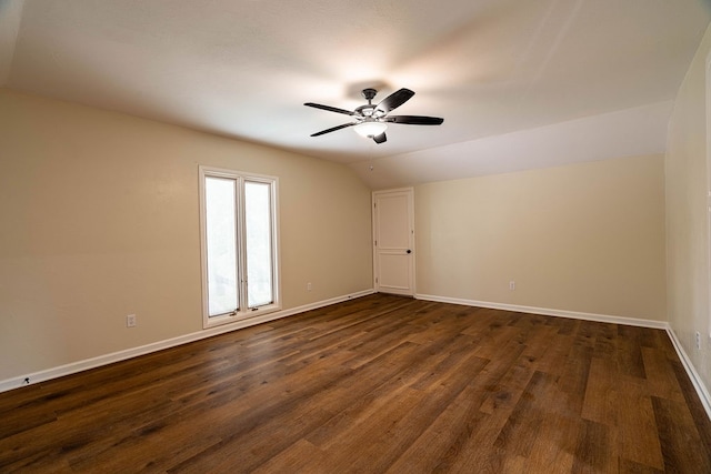 empty room featuring ceiling fan, dark hardwood / wood-style floors, and vaulted ceiling