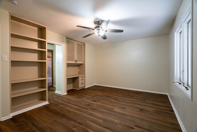 unfurnished bedroom with a closet, ceiling fan, dark hardwood / wood-style flooring, and built in desk