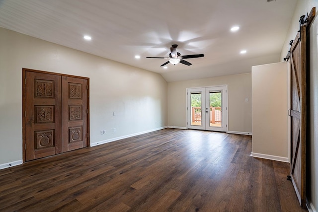 empty room with french doors, a barn door, dark hardwood / wood-style flooring, and ceiling fan