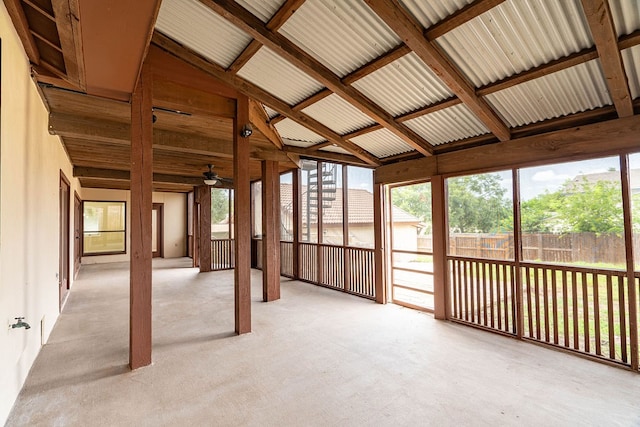 unfurnished sunroom with ceiling fan, a healthy amount of sunlight, and lofted ceiling