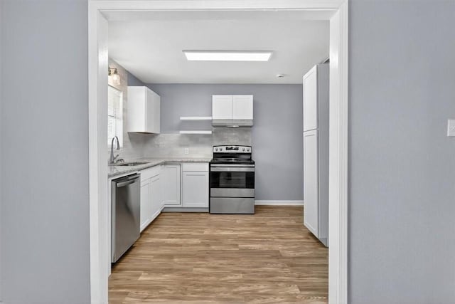 741 Lansdown Dr, Corpus Christi, TX 78412 - kitchen with stainless steel appliances, light wood finished floors, white cabinets, and under cabinet range hood