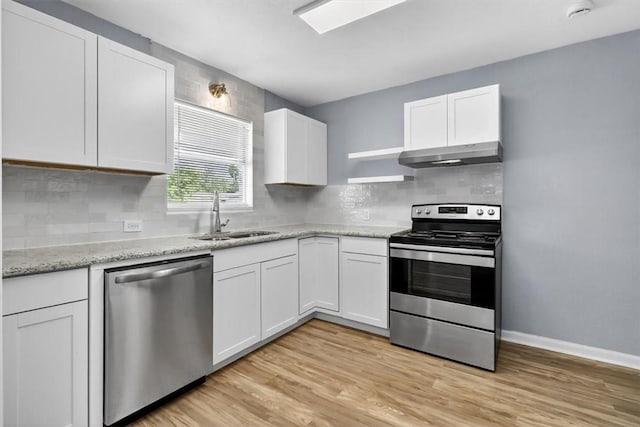 741 Lansdown Dr, Corpus Christi, TX 78412 - kitchen featuring stainless steel appliances, under cabinet range hood, white cabinets, light wood-type flooring, and decorative backsplash