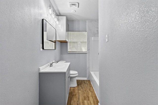 741 Lansdown Dr, Corpus Christi, TX 78412 - full bathroom featuring vanity, a textured wall, wood finished floors, and washtub / shower combination