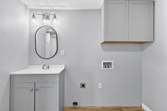 741 Lansdown Dr, Corpus Christi, TX 78412 - laundry room featuring washer hookup, hookup for an electric dryer, cabinet space, wood finished floors, and a textured wall