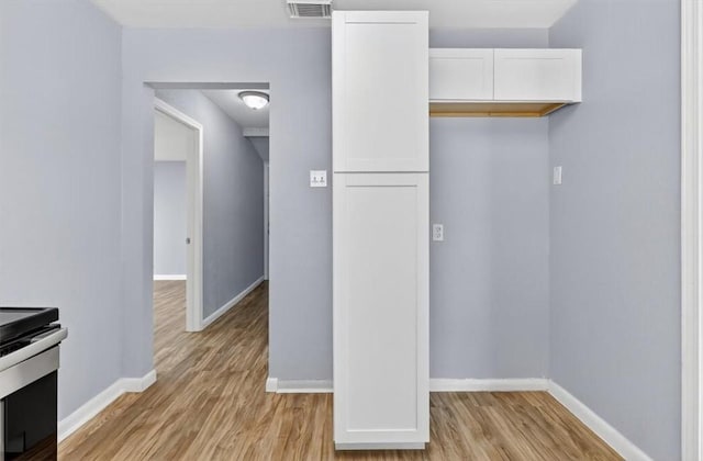 741 Lansdown Dr, Corpus Christi, TX 78412 - kitchen featuring white cabinets, stainless steel electric range, and light wood-style floors