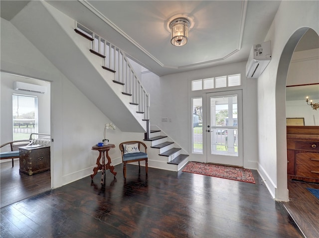 foyer entrance with a wall mounted AC and dark hardwood / wood-style flooring