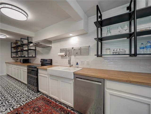 kitchen featuring butcher block counters, white cabinetry, wall chimney range hood, stainless steel dishwasher, and black range with electric stovetop