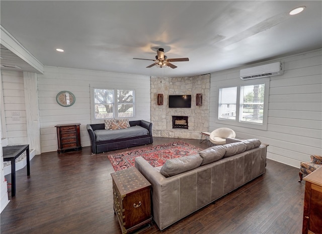 living room featuring dark hardwood / wood-style flooring, ceiling fan, wooden walls, and a wall mounted AC