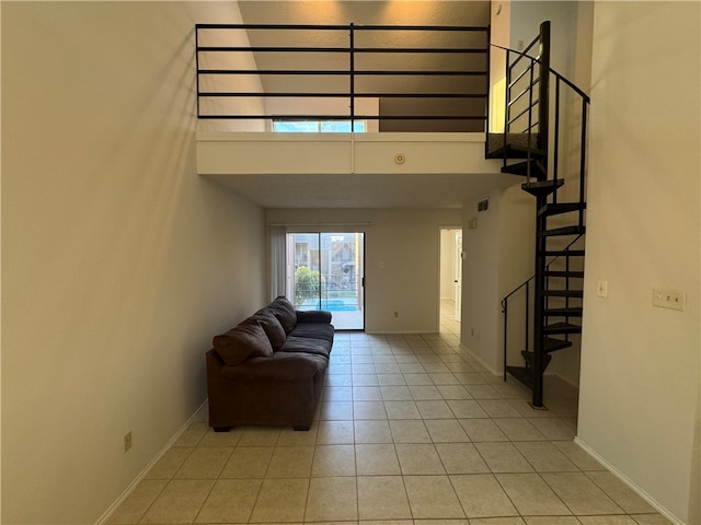 unfurnished living room featuring light tile patterned flooring and a high ceiling