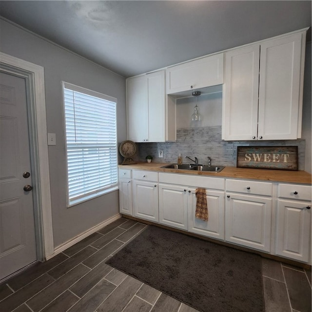 kitchen featuring white cabinets, sink, and backsplash