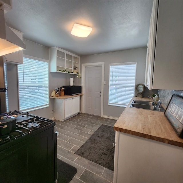 kitchen with white cabinetry, black range with gas cooktop, a healthy amount of sunlight, and sink