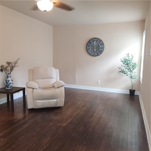 living area featuring dark wood-type flooring and ceiling fan