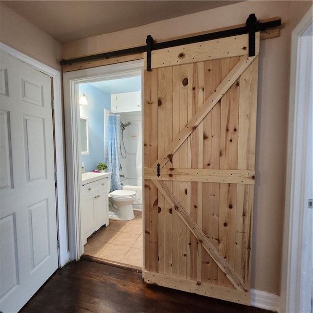 bathroom with shower / bath combo, hardwood / wood-style flooring, and toilet