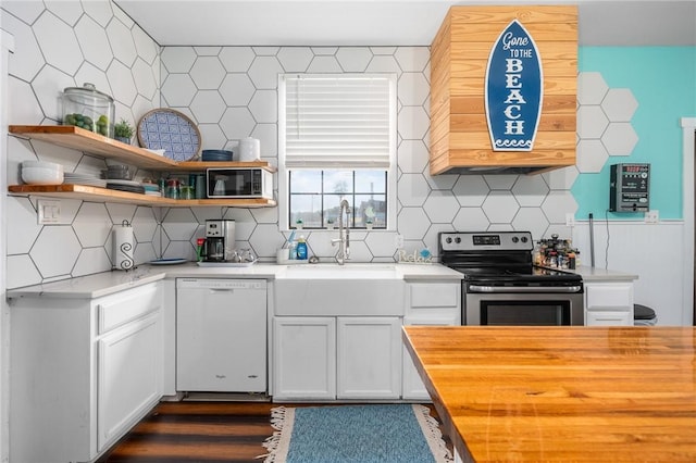 kitchen with butcher block counters, a sink, stainless steel range with electric cooktop, backsplash, and dishwasher